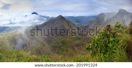 Panorama of The Batur volcano crater in cloudy weather with Agung volcano in behind, Bali, Indonesia