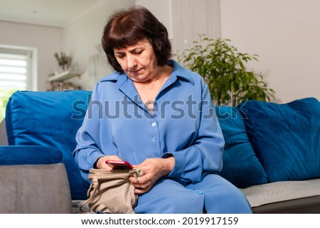 The older woman is looking for something in the handbag