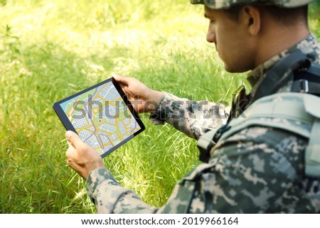 Soldier using tablet in forest. Modern technology