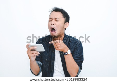 Young Asian man cry and sad when looking on the smartphone. 