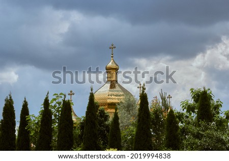 Dome of the church and green trees.