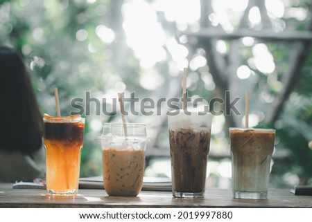 Four iced coffee drinks such as Mocha, black coffee mix orange juice, Latte and cappuccino with paper straw