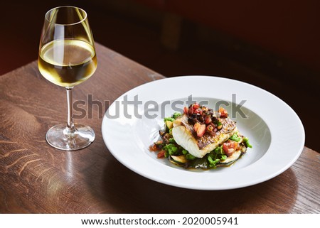 White wine and cod dish in restaurant Royalty-Free Stock Photo #2020005941