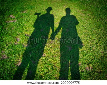 Couples shadows on green grass.