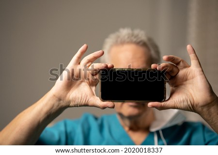 Man holding up his smart phone to hide his identity and keep privacy