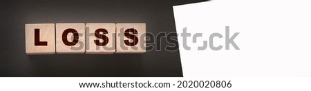 Wooden cubes with LOSS word on blacktable. Financial loss busines concept.