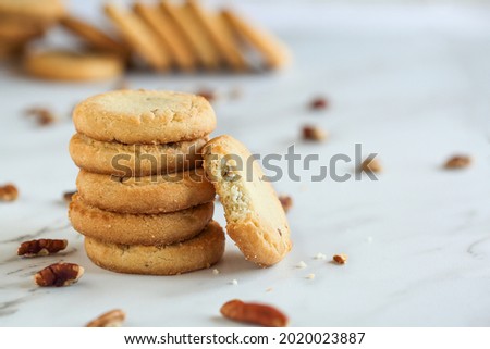 Stack of pecan sandies cookies with one missing a bite. Selective focus with blurred foreground and background. Royalty-Free Stock Photo #2020023887