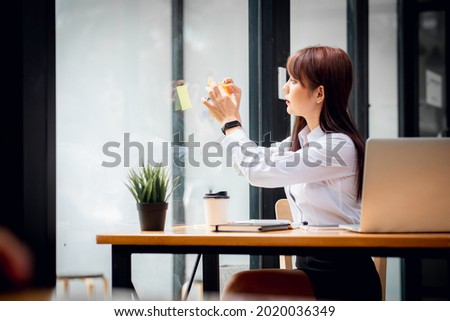 Asian happy Young beautiful businesswoman sitting in workplace, doing finances,accounting analysis,report,data and pointing graph.