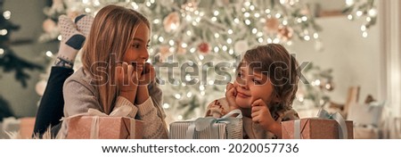 The little boy and girl decorate a christmas tree