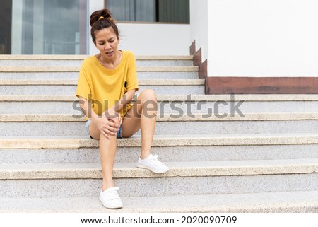 woman resting on the stairs holding her ankles. As his legs trembled, he couldn't go down the stairs. The concept of Guillain barre syndrome disease and numbness or side effects of vaccines