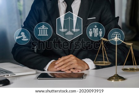 Law and Legal services concept, Lawyer businessman working with digital tablet and laptop computer at the table office and law technology innovation interface icons, Blurred background.