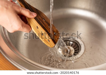 Washing a spatula under the water Royalty-Free Stock Photo #2020140176