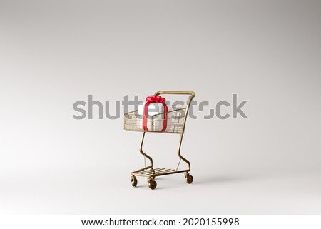 Minimal background for Christmas online shopping concept. Gift box and golden shopping cart trolley on grey background. 3d rendering illustration. Object isolate clipping path included.