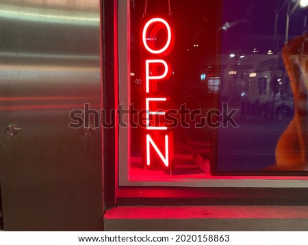 Neon open window signage in a byward market store front window downtown Ottawa.