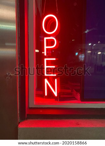 Neon open window signage in a byward market store front window downtown Ottawa Ontario Canada.