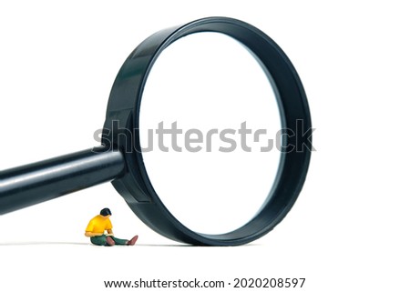 Miniature people toy figure photography. A men student sitting beside magnifier glass while reading, isolated on white background. Image photo