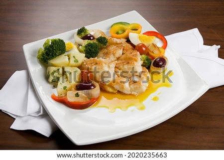 cod fish with boiled vegetables, saute potatoes, cherry tomatoes, broccoli, eggs and rice on table background.