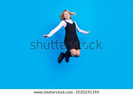 Full length photo of cheerful young active girl jump up good mood school isolated on blue color background