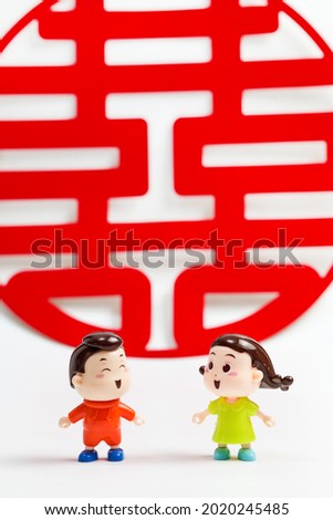 Two dolls and the Chinese character "Xi" in red