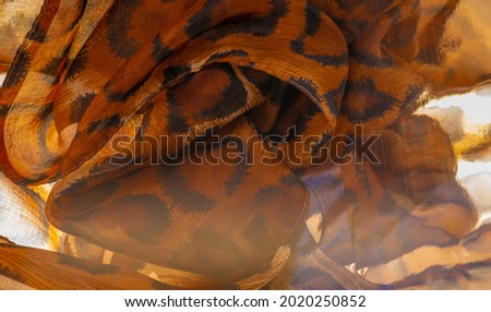Light fine silk fabric, cheetah skin, brown. African savanna theme. Background texture, pattern