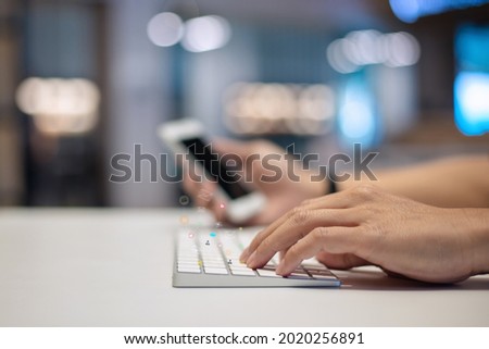 Businessman using a social media marketing concept on keyboard computer with notification icons of ove, chat, message and comment above computer keyboard.