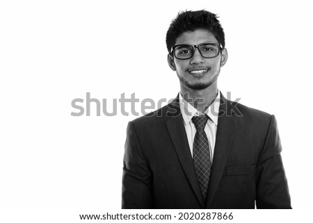 Portrait of young handsome Indian man in studio shot in black and white