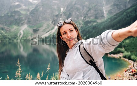 Travel influencers. Beautiful young woman blogger with smartphone on summer nature background. Mountain rock landscape. Traveling and freelancing, modern lifestyle concept