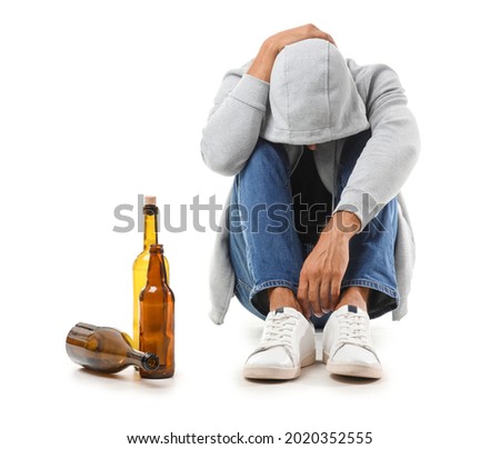 Male junkie with alcohol on white background Royalty-Free Stock Photo #2020352555