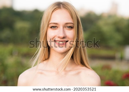 Close-up portrait of attractive caucasian young blonde woman in the park on a warm summer day. Natural Beauty, Youth, Freedom.