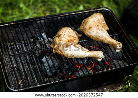 Grilled chicken thigh on a fiery grill. Cooking food on an open fire, outside. Homemade food, barbecue.