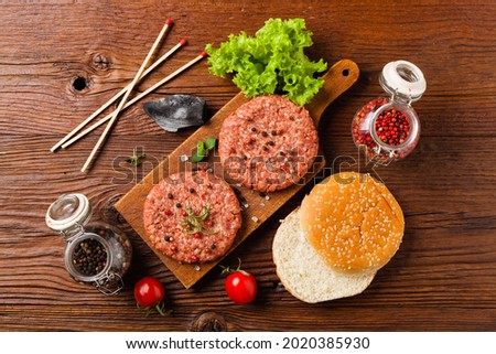 Raw beef burger, ready for grilling. Grill accessories. Concept. Free space for description. Top view.