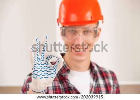 repairman making a perfect gesture with his gloved hand with focus to his hand