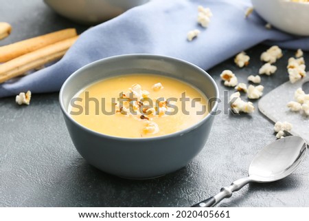 Bowl with tasty popcorn soup on dark background