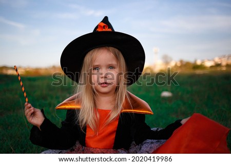 little cute girl dressed as a witch celebrates halloween.