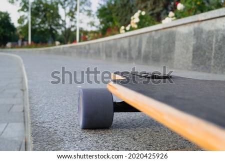 Closeup to skateboard trucks and wheels on rough asphalt road