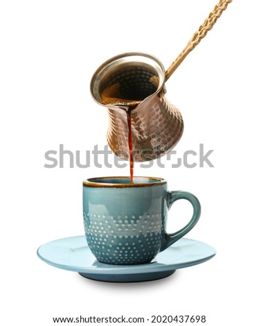 Pouring hot coffee from cezve into cup on white background Royalty-Free Stock Photo #2020437698