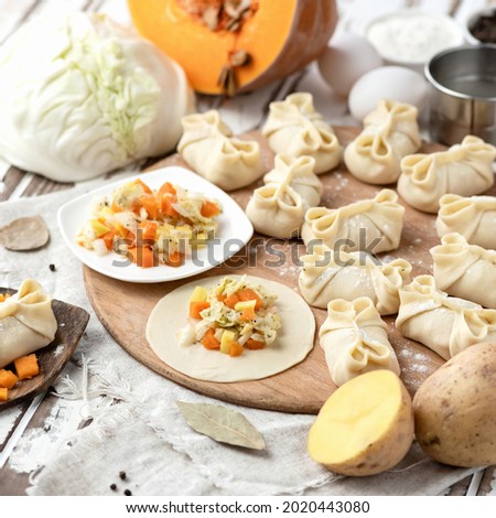Making Process of dumplings with potatoes, pumpkin and cabbage. Vegetable ingredients and kitchen utensils on kitchen table. Convenience Food. Close-up shot. Side view. Soft focus.