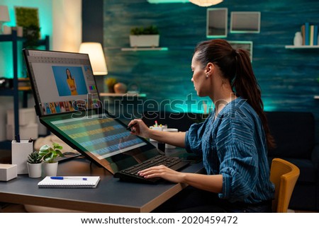 Graphic software editor working on touchpad monitor computer to retouch lights and gradient on photo at modern office. Artistic woman using photo retouching template for digital project