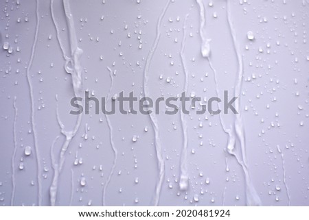 Raindrops fell on the wall and saw the raindrops flowing in a long way.The water flowed through the walls as a stream of water splashed and saw beautiful patterns. Royalty-Free Stock Photo #2020481924