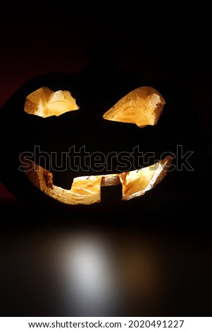 creepy pumpkin for halloween, halloween symbol on a leavened black background, burning pumpkin eyes