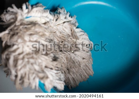Cleaning dirty mop in plastic basin. soft picture. selective focus