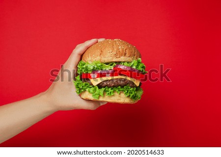 Concept of tasty food with burger on red background