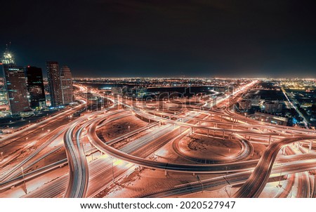 Night time aerial picture of the Sheikh zayed road traffic overpass with cars driving on the highway, creating light trails