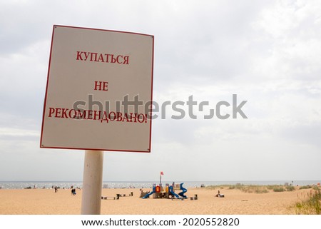 The inscription on the beach in Russian "Swimming is not recommended"