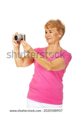 A portrait of an old Polish woman taking a photo with her vintage camera,,isolated on white