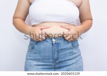 Beautiful fat woman using her hands to squeeze out excess fat that is isolated on a white background. she wants to lose weight The concept of abdominal fat surgery. Royalty-Free Stock Photo #2020601129