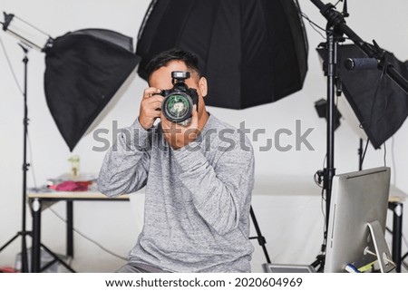 Photographer holding camera and taking a photo