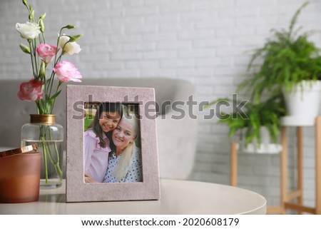 Framed family photo on light table in living room. Space for text