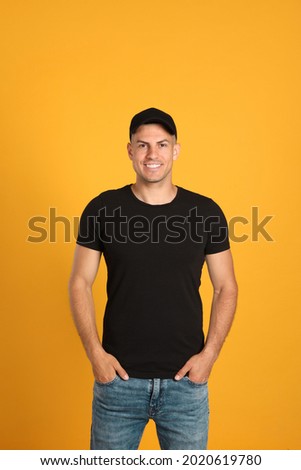 Happy man in black cap and tshirt on yellow background. Mockup for design