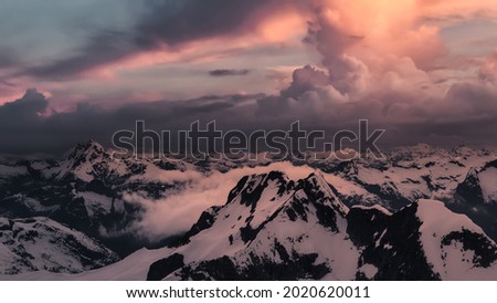 Aerial view from above of White Glacier Mountains. Canadian Nature Background. Located near Vancouver, British Columbia, Canada. Dark Sunset Sky Art Render